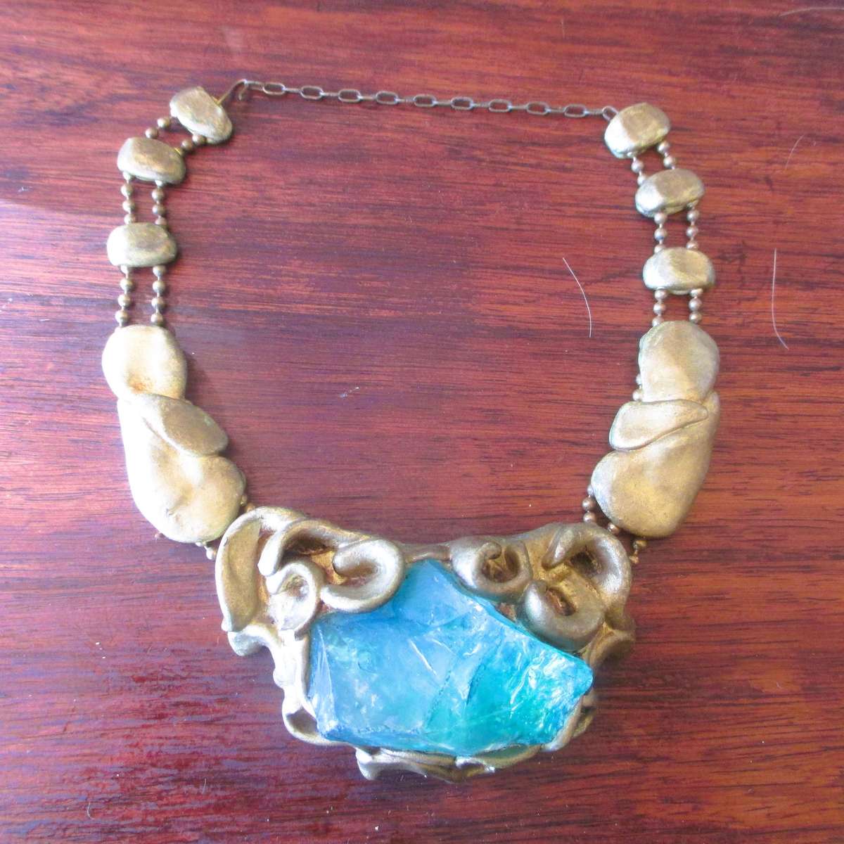 Bulky stage clay jewelry with large blue centre.