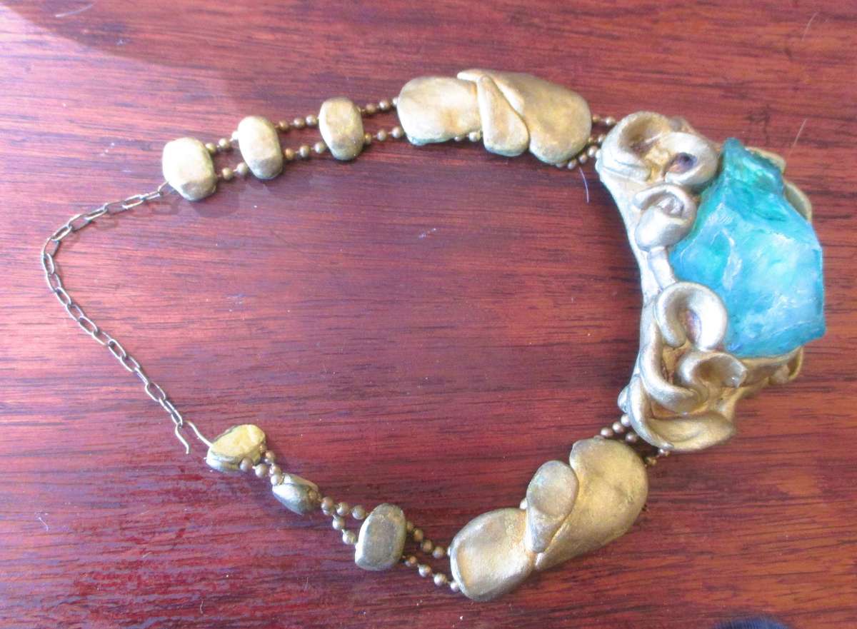 Bulky stage clay jewelry with large blue centre.