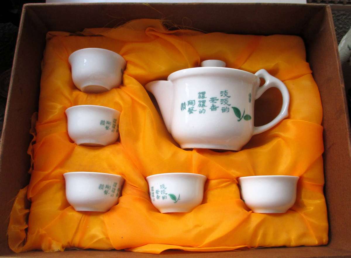 Boxed Chinese porcelain set includes a teapot and five tea cups featuring green leaf illustrations