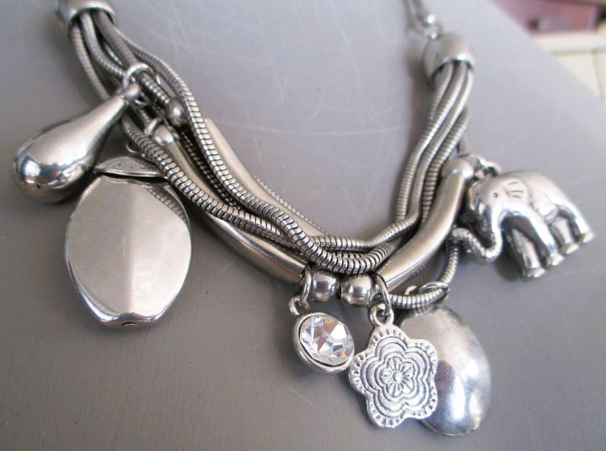silver-tone multi-strand charm necklace, prominent elephant pendant and a sparkling rhinestone,