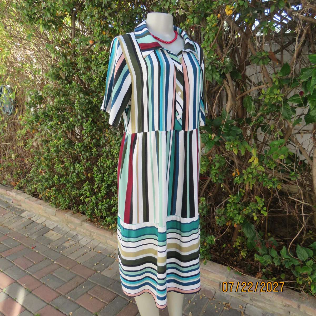 Vertical striped sheath dress in attractive colours. Four button opening. 100% viscose. Size 40