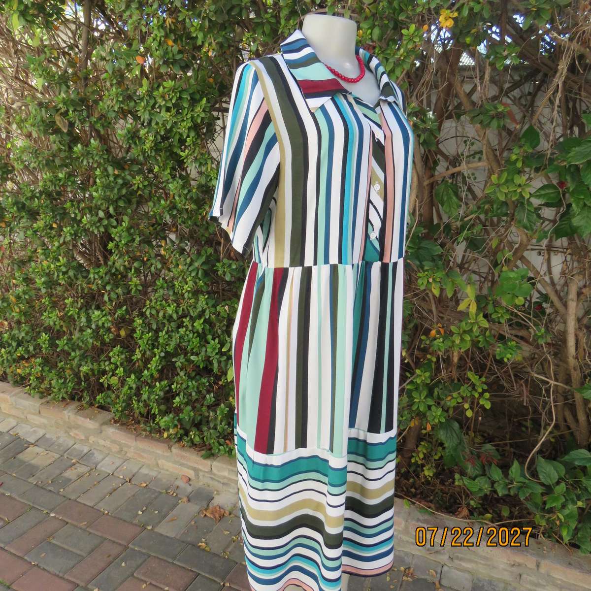 Vertical striped sheath dress in attractive colours. Four button opening. 100% viscose. Size 40