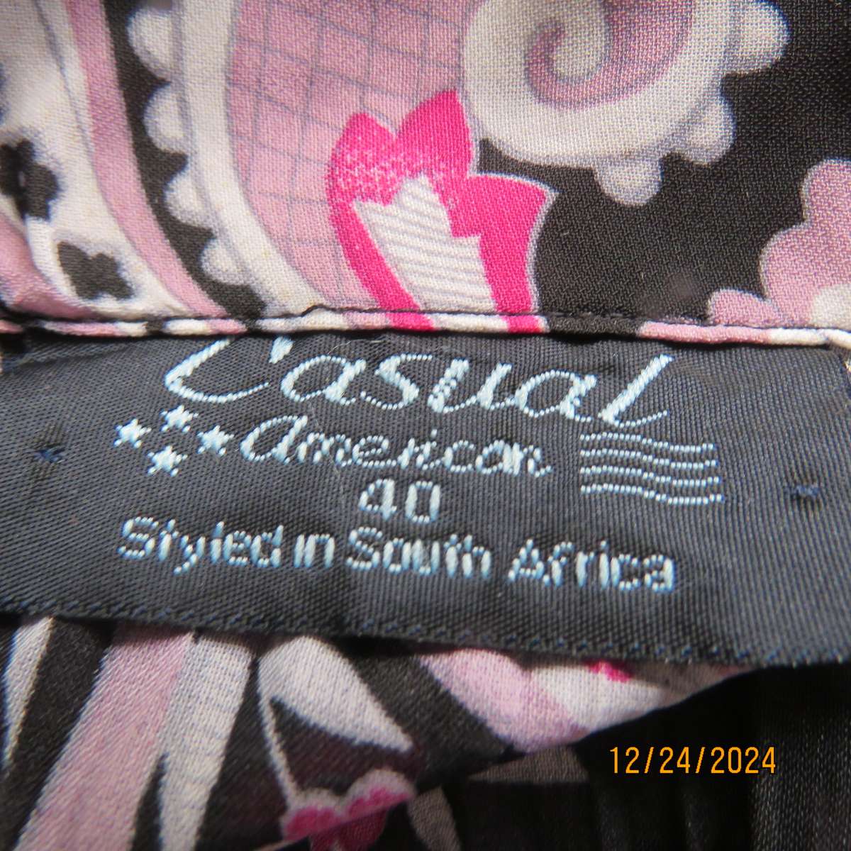 Permanent pleated black/pink/white bo-ho patterned button down long sleeve top. Size 40. Sheer poly.