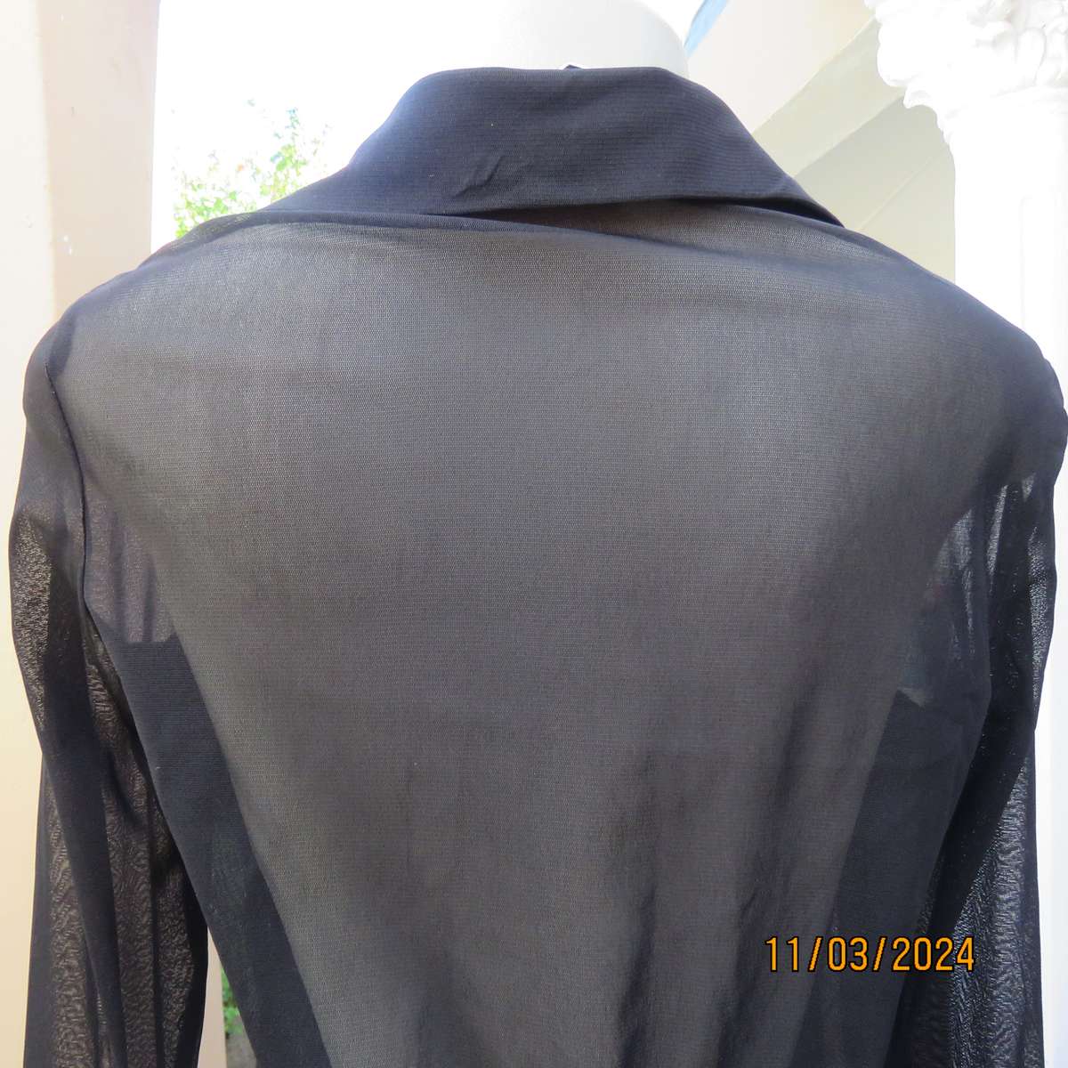 Black stretch nylon long sleeve button down top with frilled bib. Size 36.