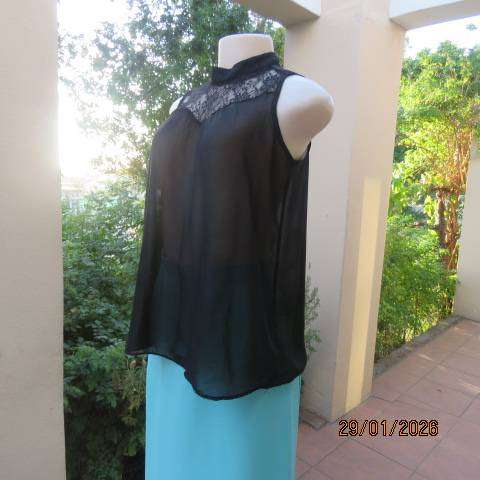 Black sleeveless sheer polyester top with lace front yoke. Opening at back. Size 34