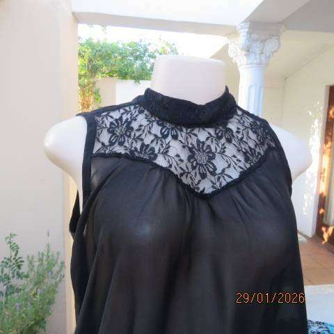 Black sleeveless sheer polyester top with lace front yoke. Opening at back. Size 34