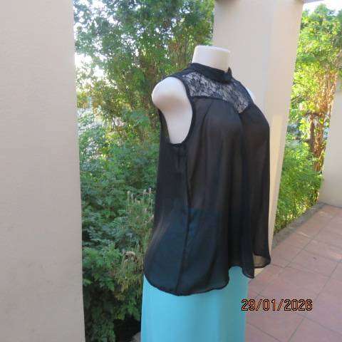 Black sleeveless sheer polyester top with lace front yoke. Opening at back. Size 34