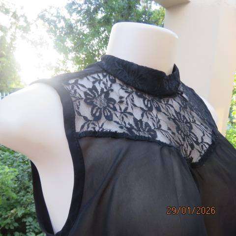 Black sleeveless sheer polyester top with lace front yoke. Opening at back. Size 34