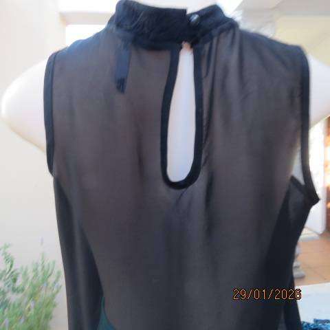 Black sleeveless sheer polyester top with lace front yoke. Opening at back. Size 34