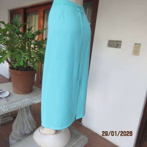 Seagreen ankle length pencil skirt in textured polyester with zip and slit at back. Size 40
