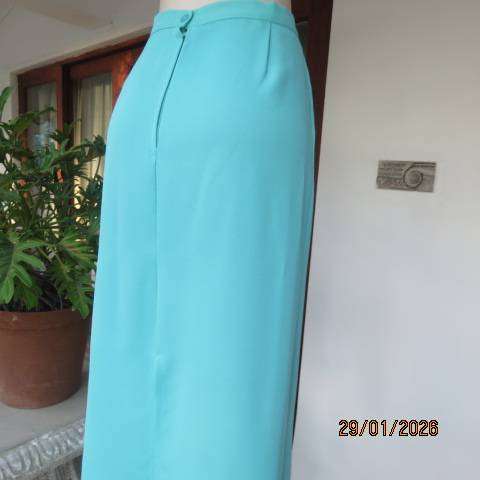 Seagreen ankle length pencil skirt in textured polyester with zip and slit at back. Size 40