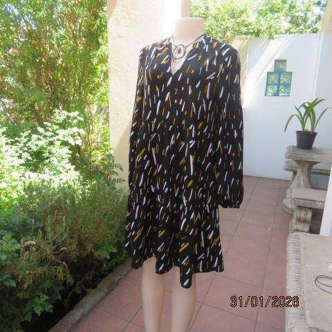 Black slip over tiered dress with white-mustard print. Soft polyester. Long sleeves. Size 32-34