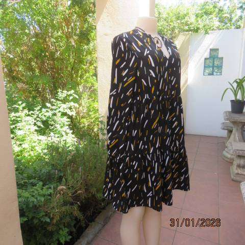 Black slip over tiered dress with white-mustard print. Soft polyester. Long sleeves. Size 32-34