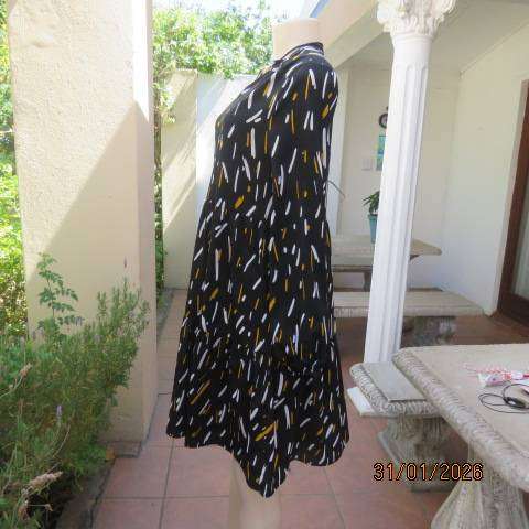 Black slip over tiered dress with white-mustard print. Soft polyester. Long sleeves. Size 32-34