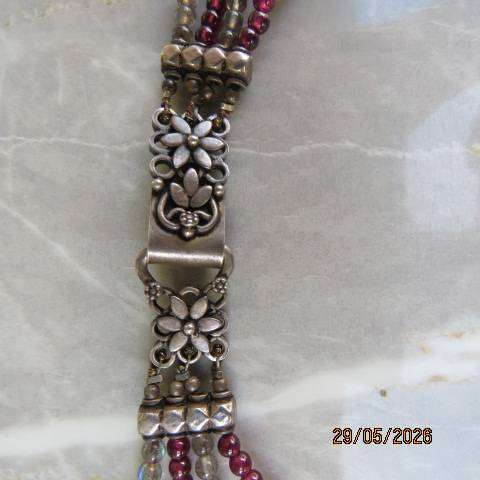 Multi-string necklace with tiny red garnets and labradorite. Floral clasp with C marking