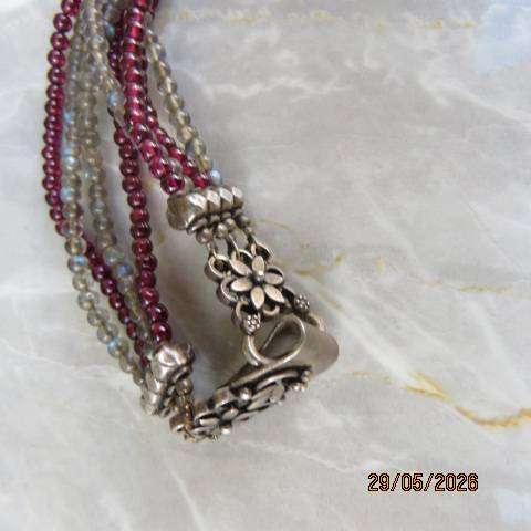 Multi-string necklace with tiny red garnets and labradorite. Floral clasp with C marking