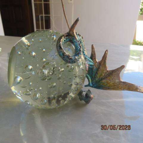 Decorative blue and gold fantasy dragon figurine perched on glass bubble ball