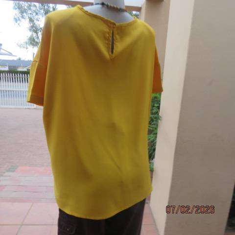 Amber yellow slip over capped sleeve polyester top. Size 42-44. Slit at back with button and loop.