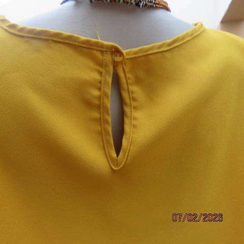 Amber yellow slip over capped sleeve polyester top. Size 42-44. Slit at back with button and loop.