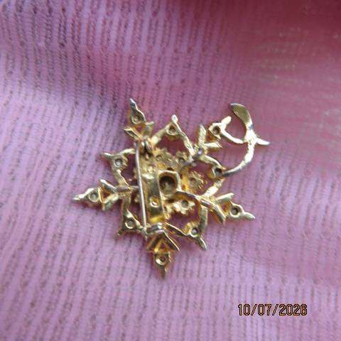 Gold toned floral brooch with ruby red stone and crystal accents