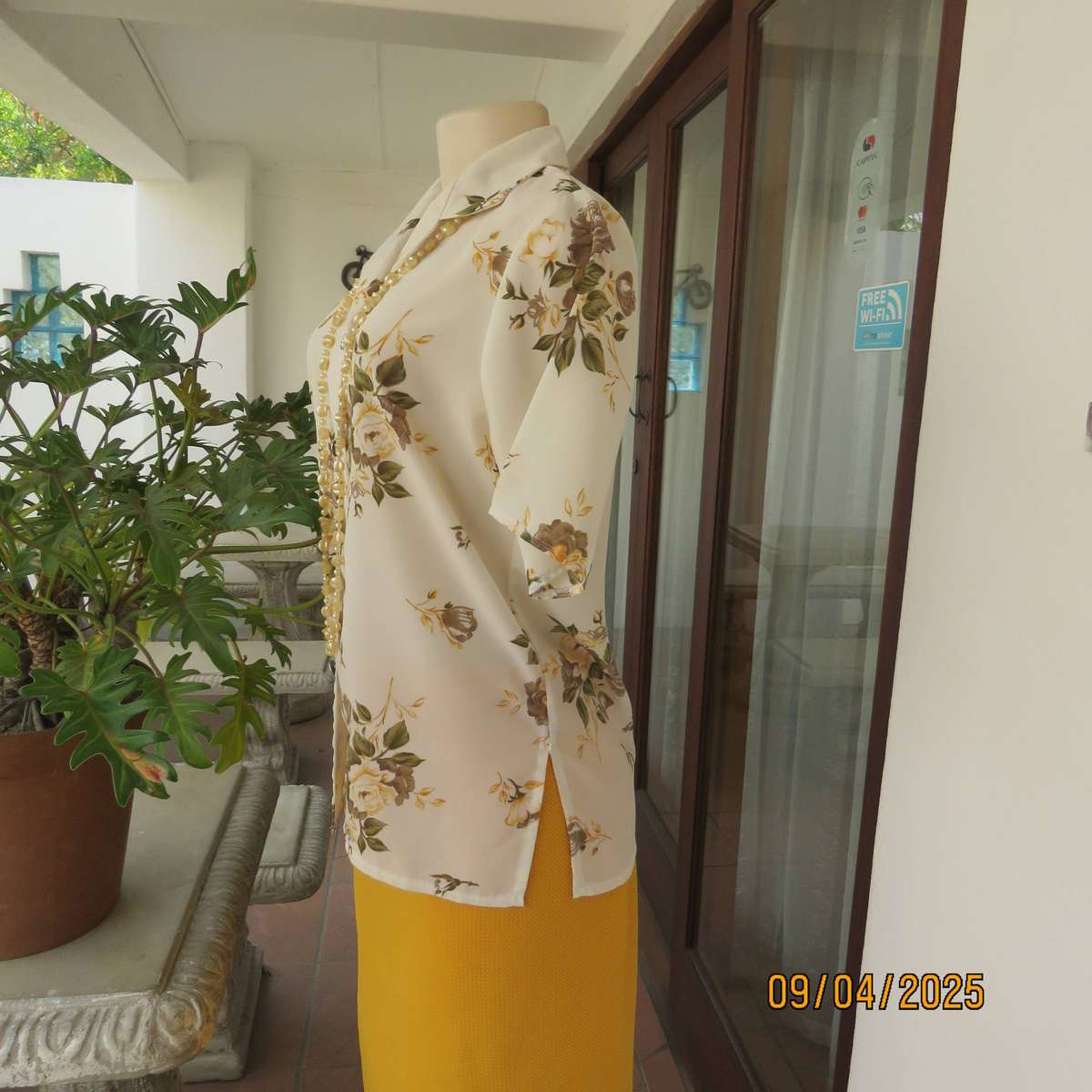 Cream button down polyester short sleeve top with yellow-green floral print. Size 34