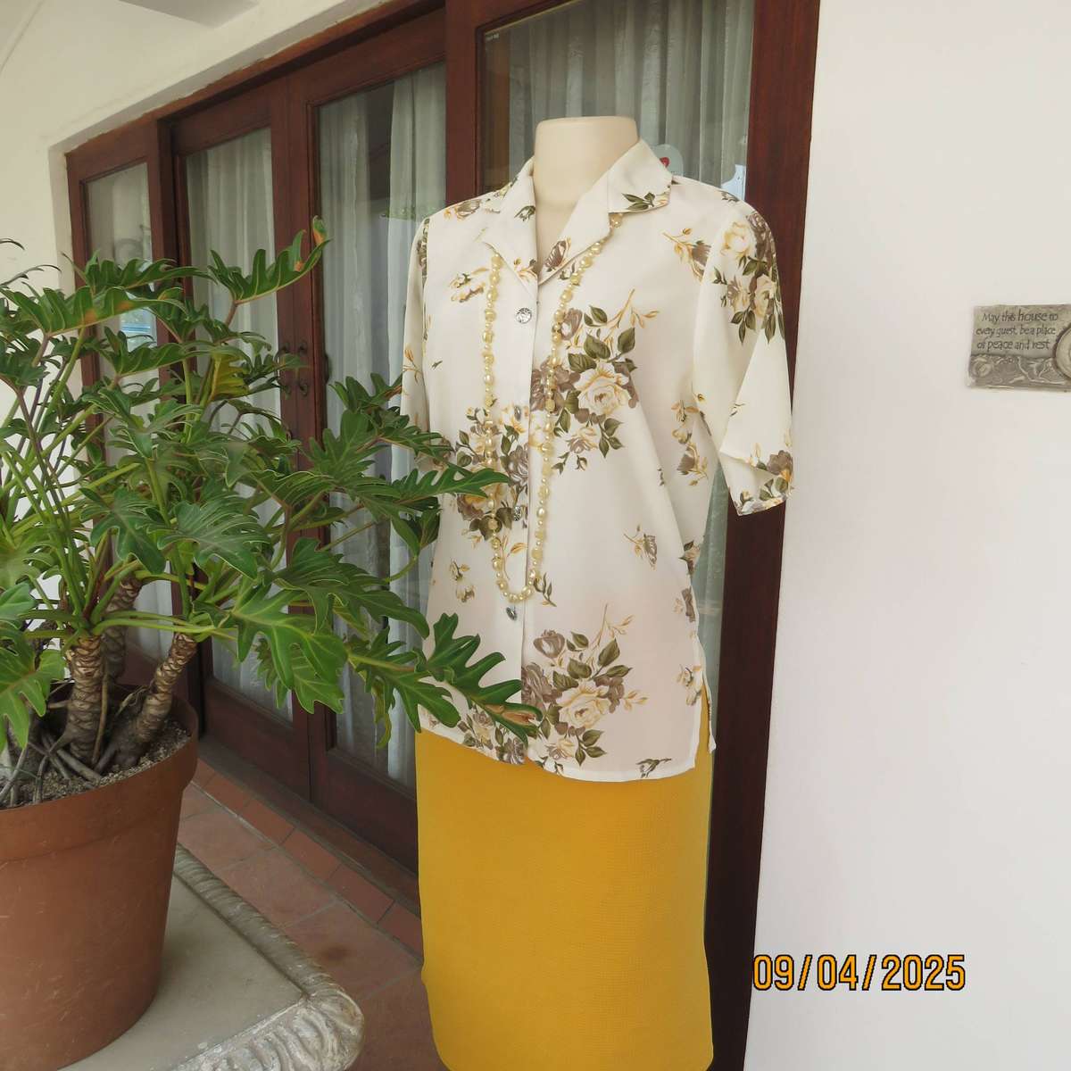 Cream button down polyester short sleeve top with yellow-green floral print. Size 34