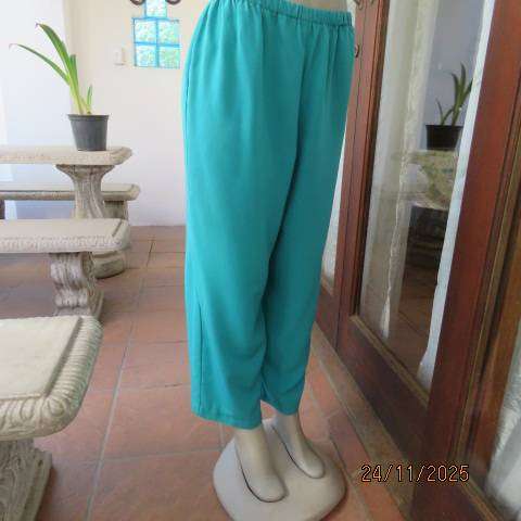 Boutique made aqua colour pants with tapered legs in polyester with elasticated waist. Size 40