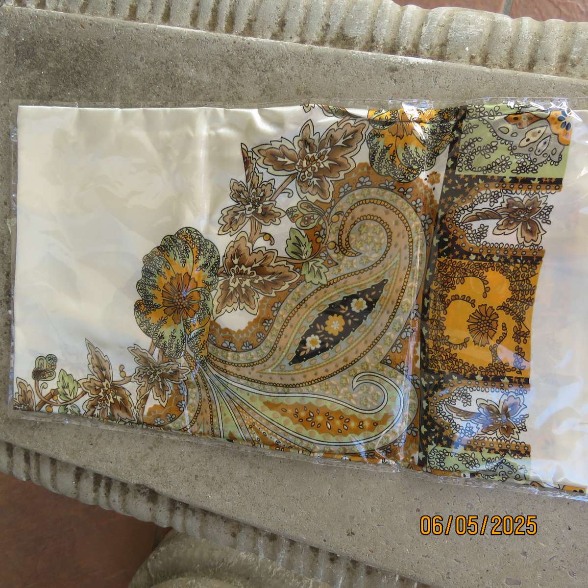Square 90cm x 90cm cream satin polyester scarf with paisley pattern border in autumn colours.