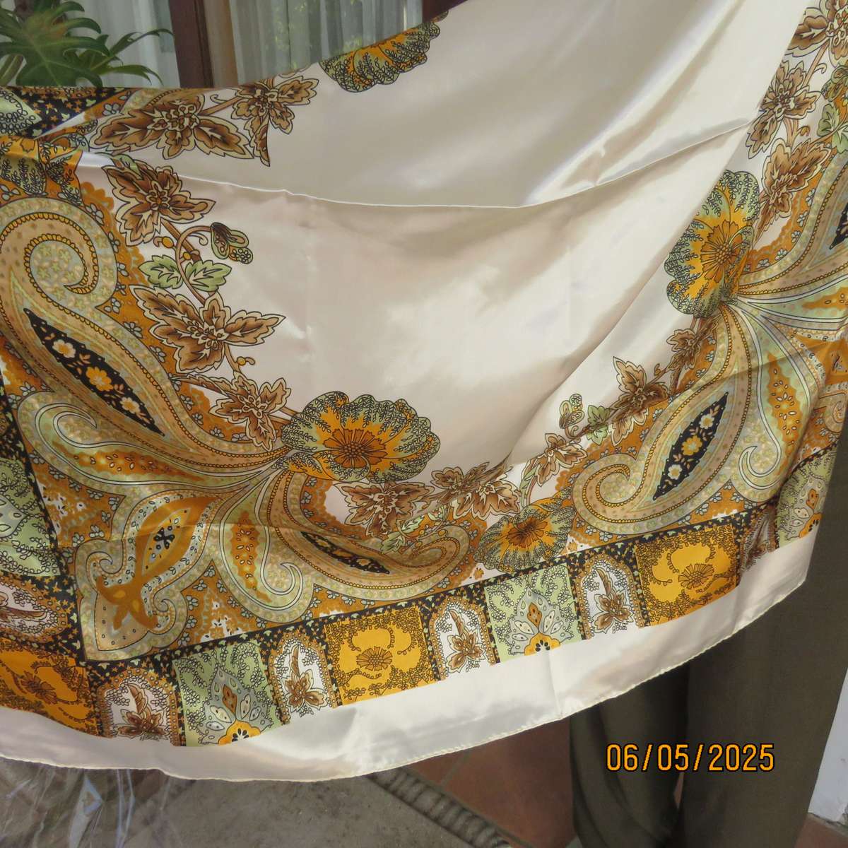 Square 90cm x 90cm cream satin polyester scarf with paisley pattern border in autumn colours.