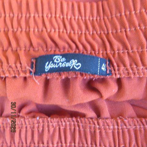 Burnt orange ankle length polyester skirt with front button decoration. Elastic waistband. Size 40