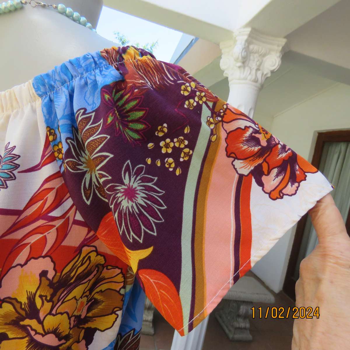 Easy to wear OR size 40-42 slip over off the shoulder top in cream-purple-blue-orange flowers.As new