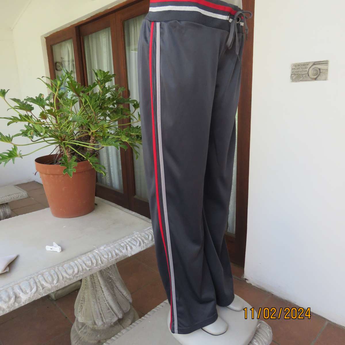 Steel grey track suit pants with wide stretch waistband in grey-red-silver. Size 38. Side stripes.