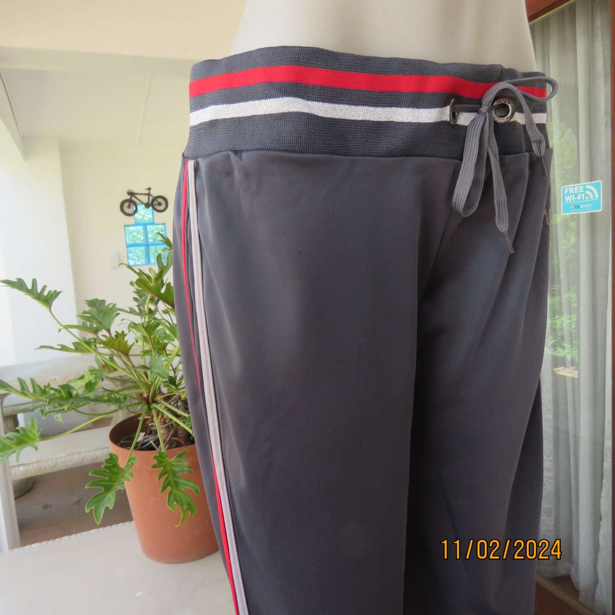 Steel grey track suit pants with wide stretch waistband in grey-red-silver. Size 38. Side stripes.