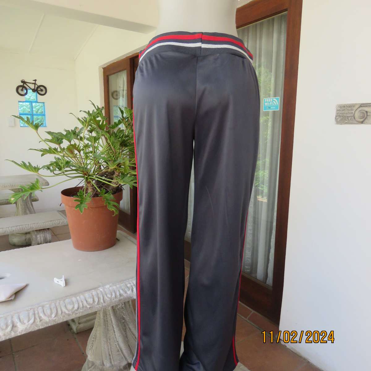 Steel grey track suit pants with wide stretch waistband in grey-red-silver. Size 38. Side stripes.