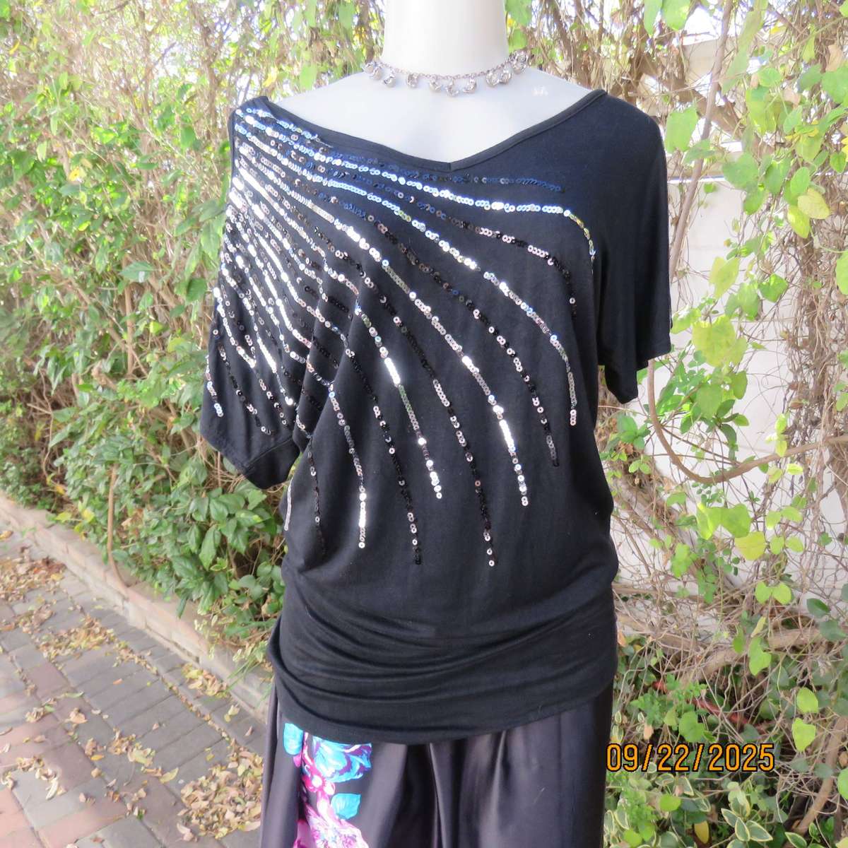 Black slip over glam top. Cut-on short sleeves. One open shoulder. Sequin decoration. Size 36