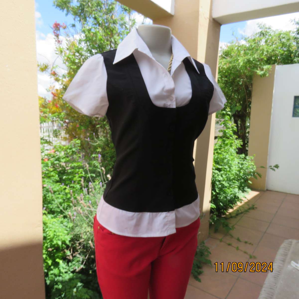 Timeless black stretch poly-rayon top with white polycotton capped sleeves and bib.Size 34.