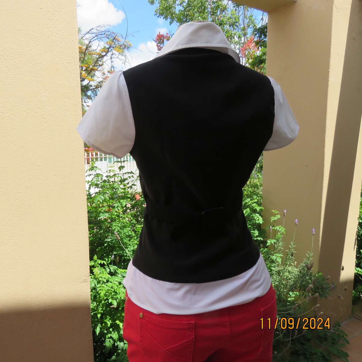 Timeless black stretch poly-rayon top with white polycotton capped sleeves and bib.Size 34.