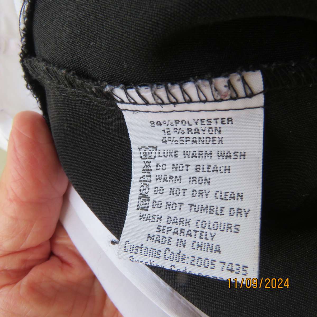 Timeless black stretch poly-rayon top with white polycotton capped sleeves and bib.Size 34.