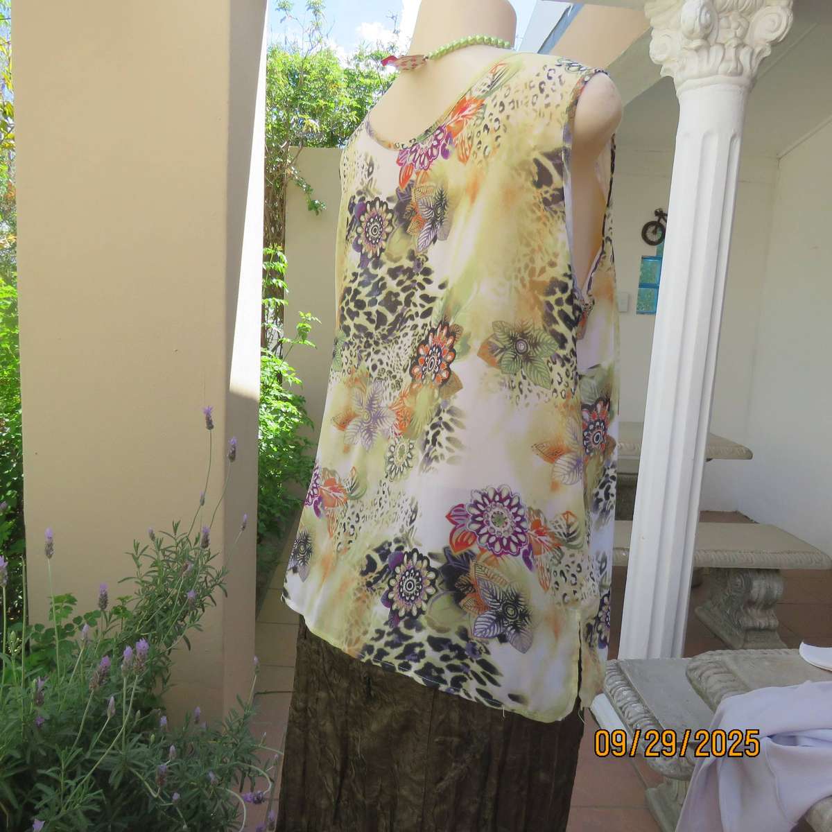 Pale green sleeveless sheer polyester top with orange-purple-black print. Front underlay. Size 42