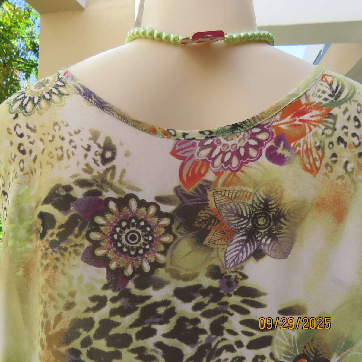 Pale green sleeveless sheer polyester top with orange-purple-black print. Front underlay. Size 42
