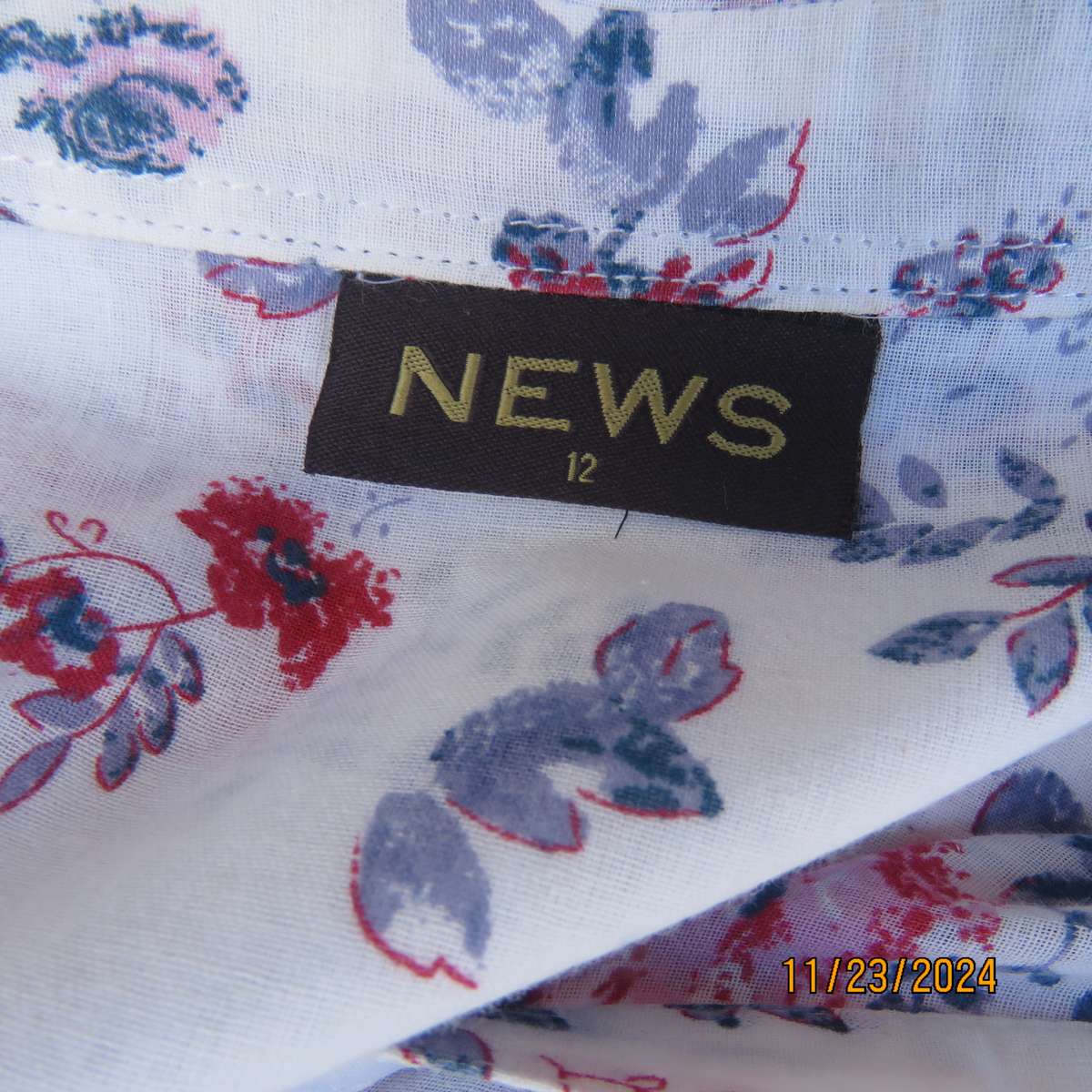 Charming tailored capped sleeve fine cotton white with red-blue floral posies. Size 36. Open collar.