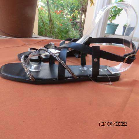 Black flat sandals with ankle strap and glam straps, size 5. Never worn.