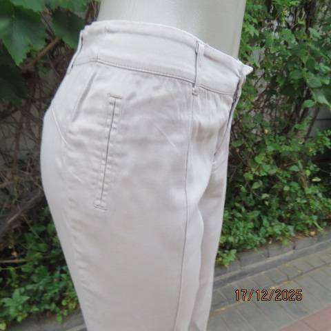 Beige stretch cotton shinny leg ankle length pants with dummy pockets. Size 38