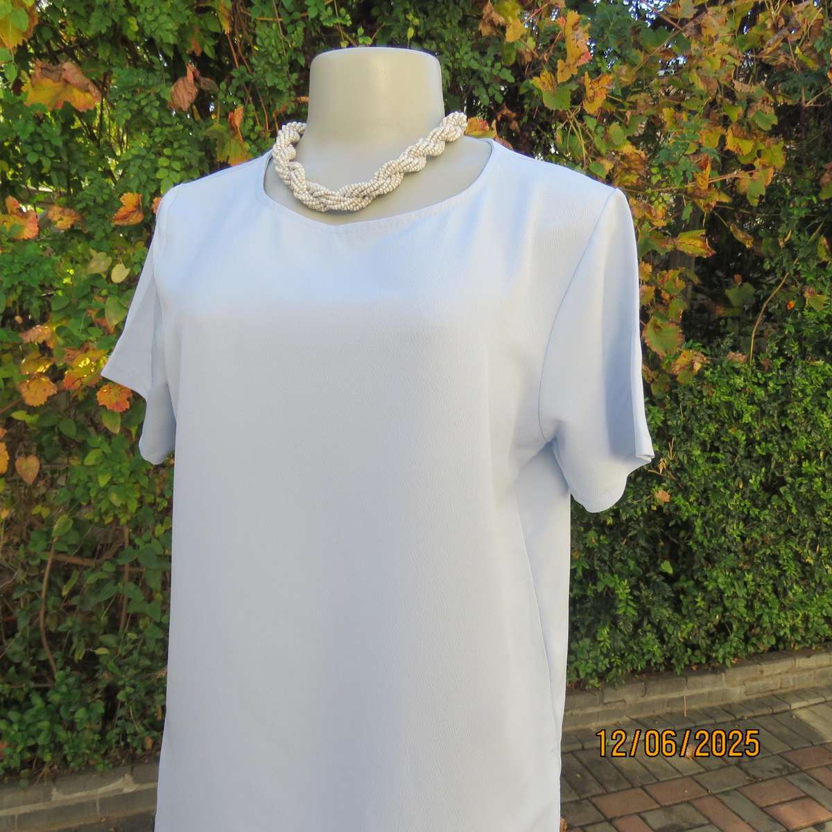 Light blue textured polyester slip over short sleeve top. Size 34. As new