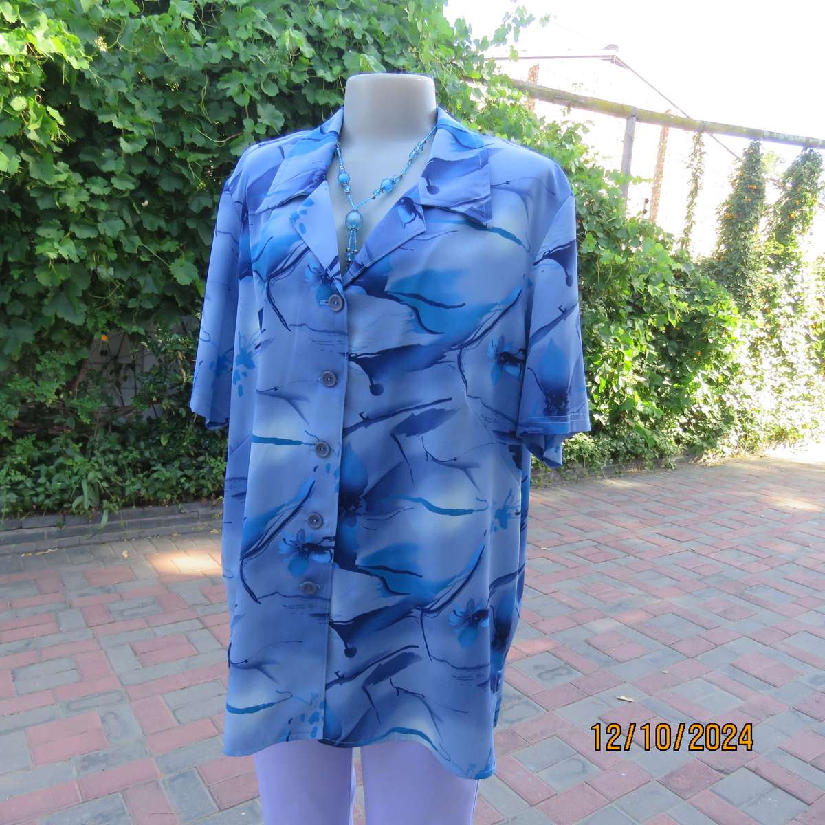 Boutique made short sleeve top in silky polyester. In medley of blues. Open collar.Size 44.As new
