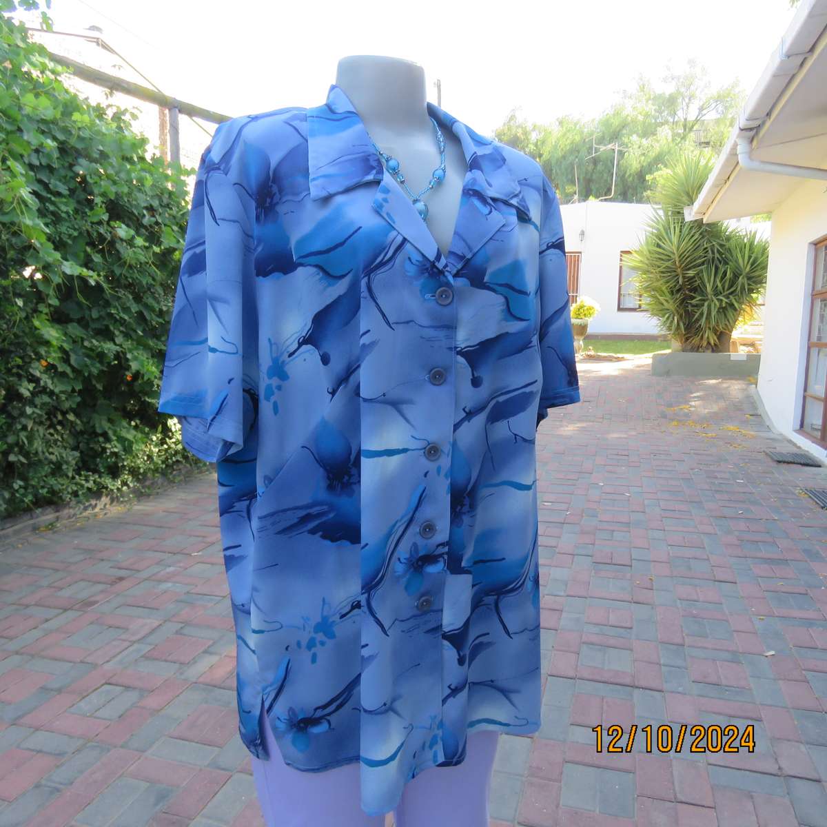 Boutique made short sleeve top in silky polyester. In medley of blues. Open collar.Size 44.As new