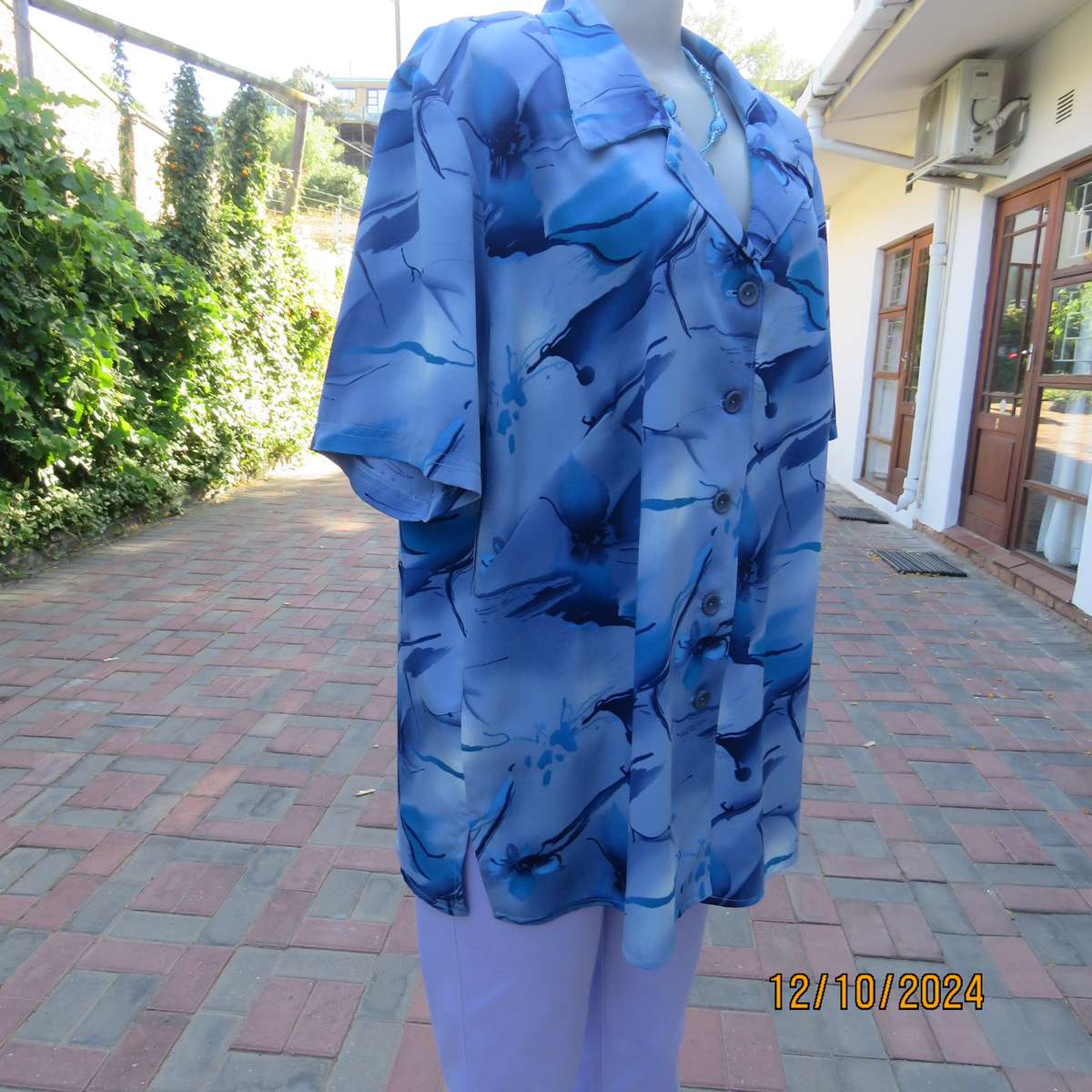 Boutique made short sleeve top in silky polyester. In medley of blues. Open collar.Size 44.As new