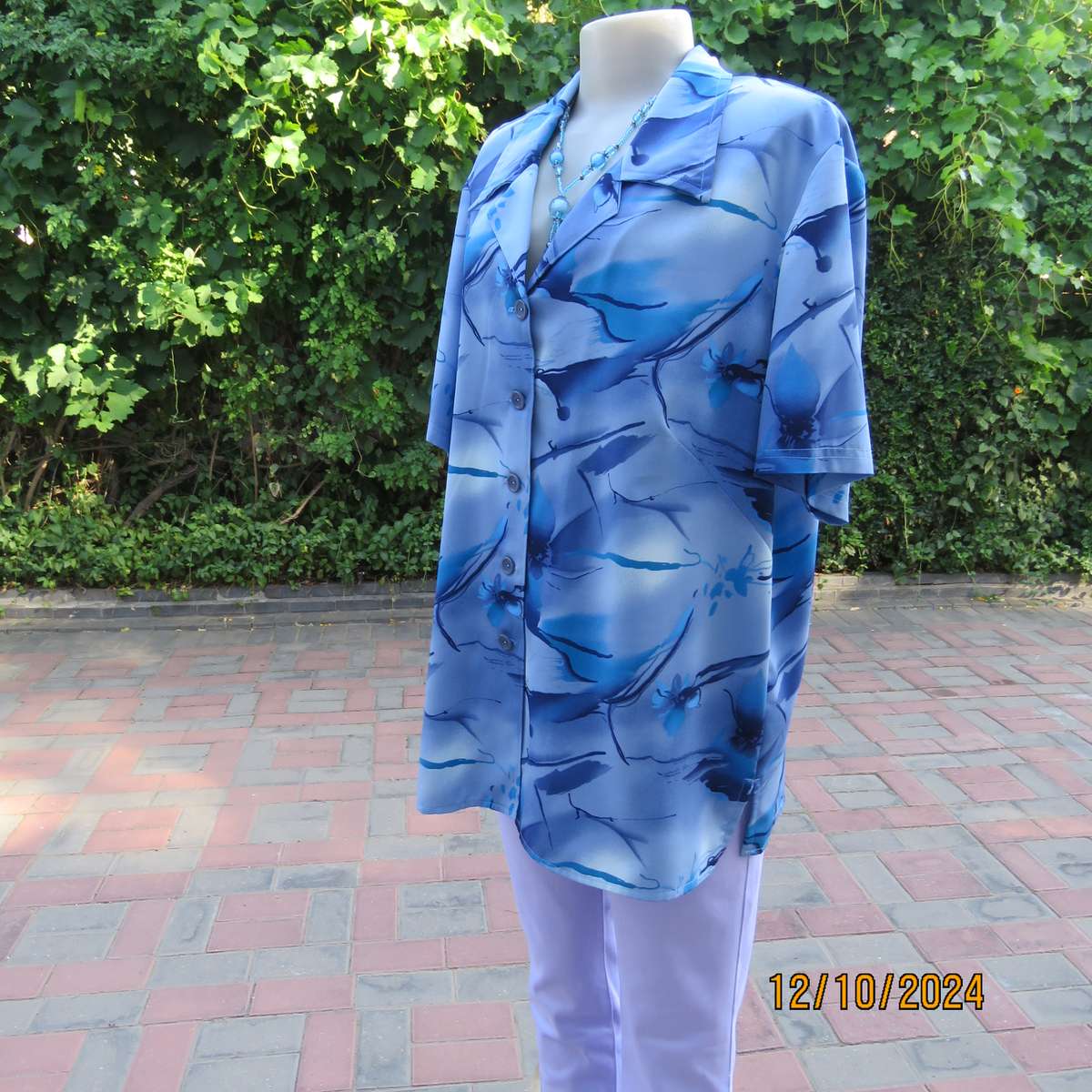 Boutique made short sleeve top in silky polyester. In medley of blues. Open collar.Size 44.As new
