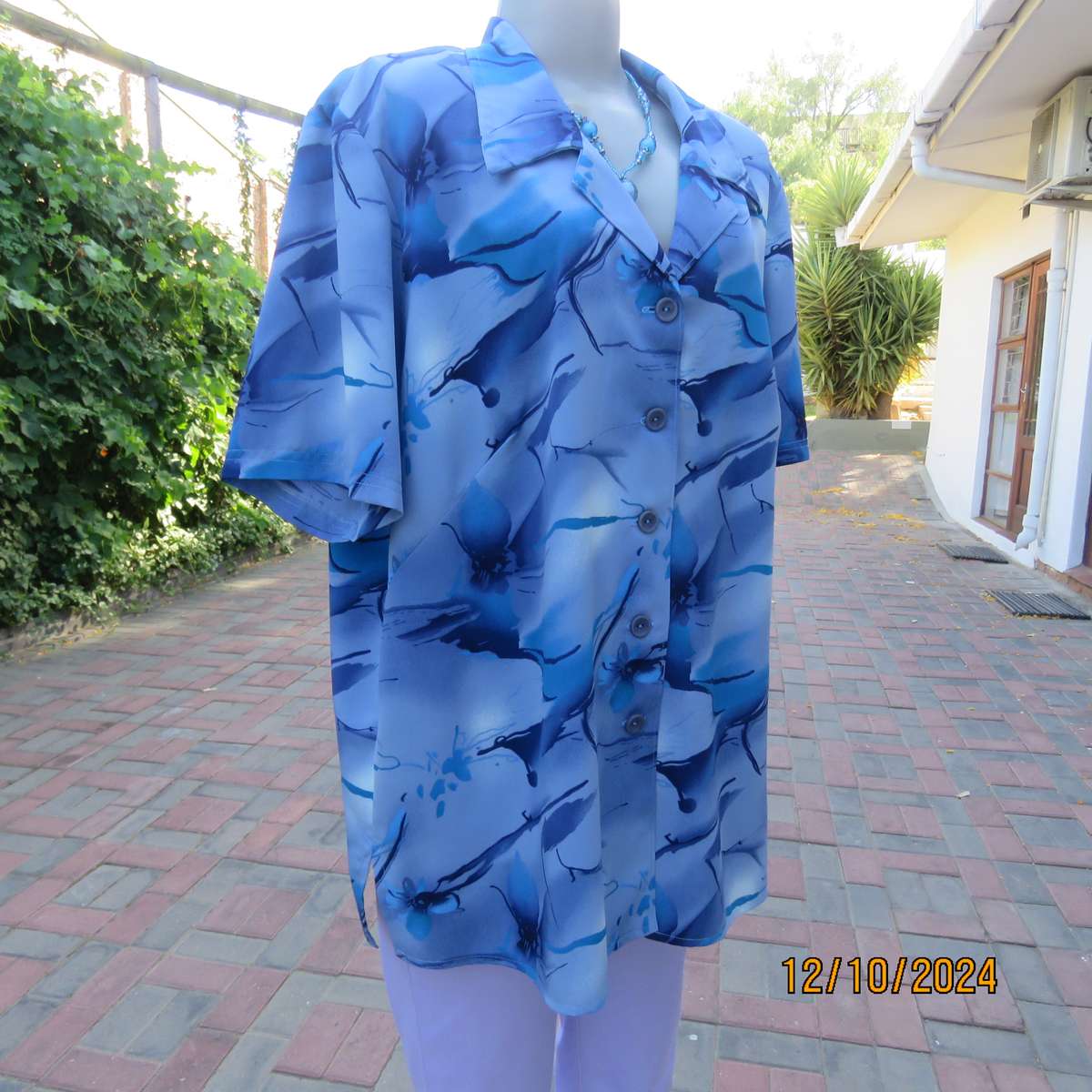 Boutique made short sleeve top in silky polyester. In medley of blues. Open collar.Size 44.As new