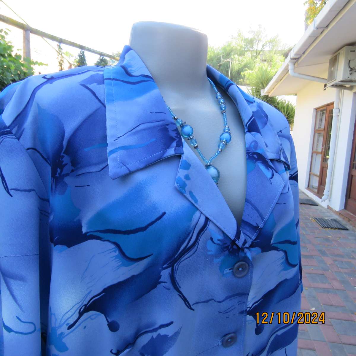 Boutique made short sleeve top in silky polyester. In medley of blues. Open collar.Size 44.As new